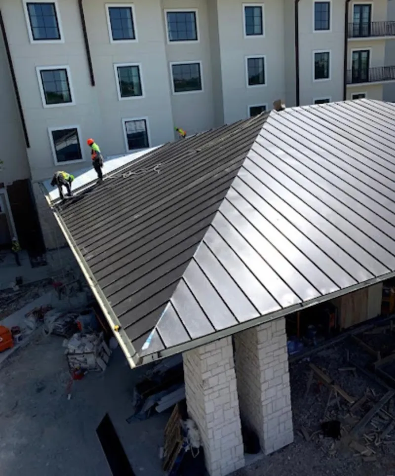 Crew installing standing seam metal roof panels on a commercial project in Findlay